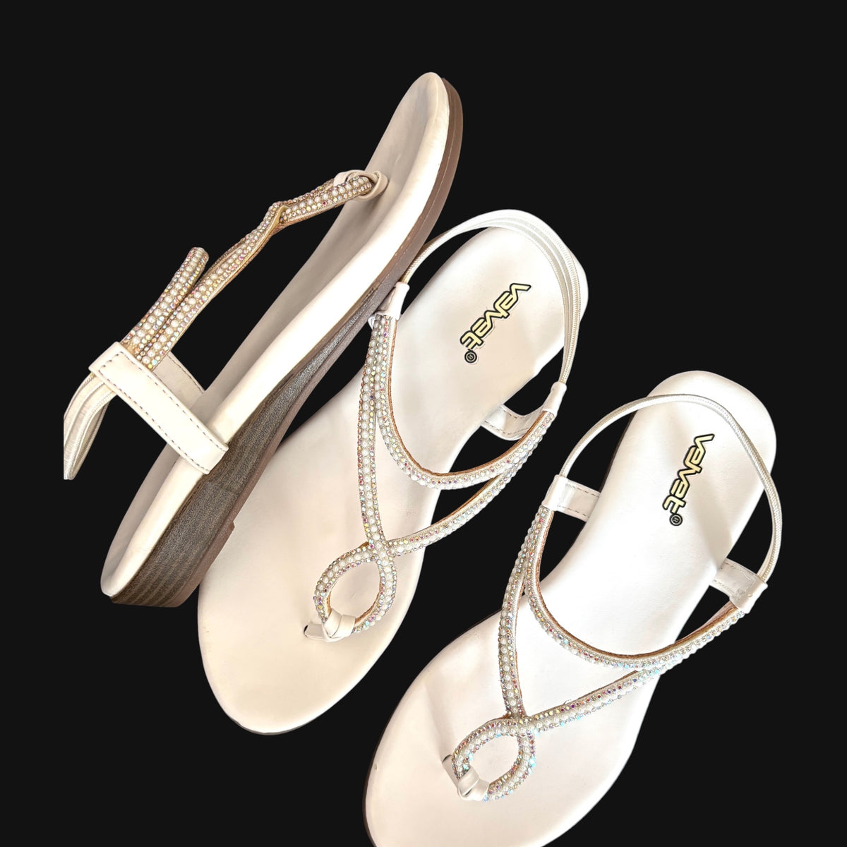 WALK WITH ASHOKA white flat slingback sandals with crystal and faux pearl embellishments on a black background